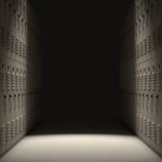 A direct top view of a row of regular school lockers in a corridor dramatically lit by a single spotlight