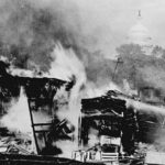 A Bonus Army encampment in Ancosta Fields is aflame after a confrontation with the U.S. military