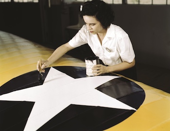Woman painting an U.S. roundel on a fighter wing