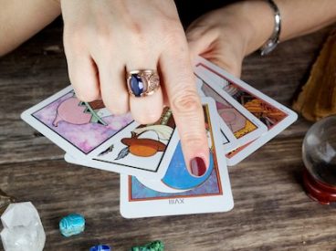 A fortune teller with a stack of tarot cards