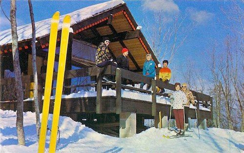 Skiers posing outside a winter lodge