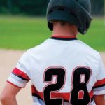 Boy in baseball uniform holding a baseball bat