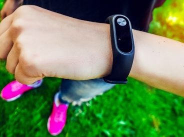 Woman's arm with a health monitoring device hung on her wrist.