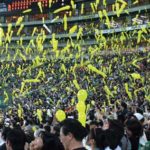 Japanese people play with balloons in a baseball stadium