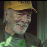 Actor Christopher Plummer wearing a yellow ball cap