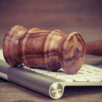 A gavel rests on an Apple keyboard.