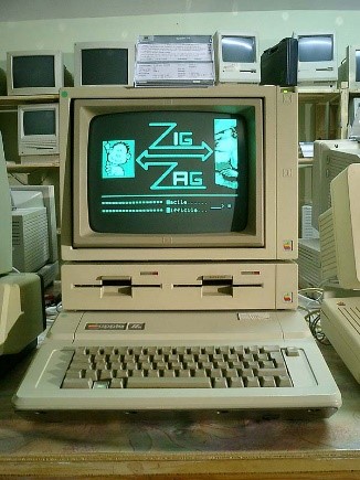 An Apple II computer on a counter, surrounded by other, old computers.