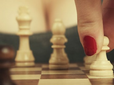 woman with red fingernails playing chess. Source: Shutterstock.com/Dima Sobko