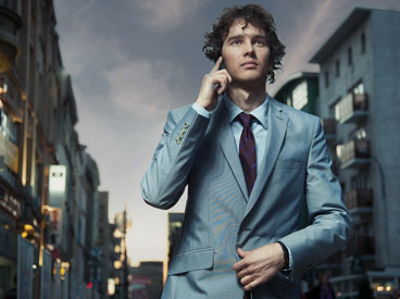 Young, wealthy businessman talking on his cellphone and walking