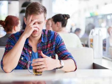 young man drinking his troubles away in a cafe