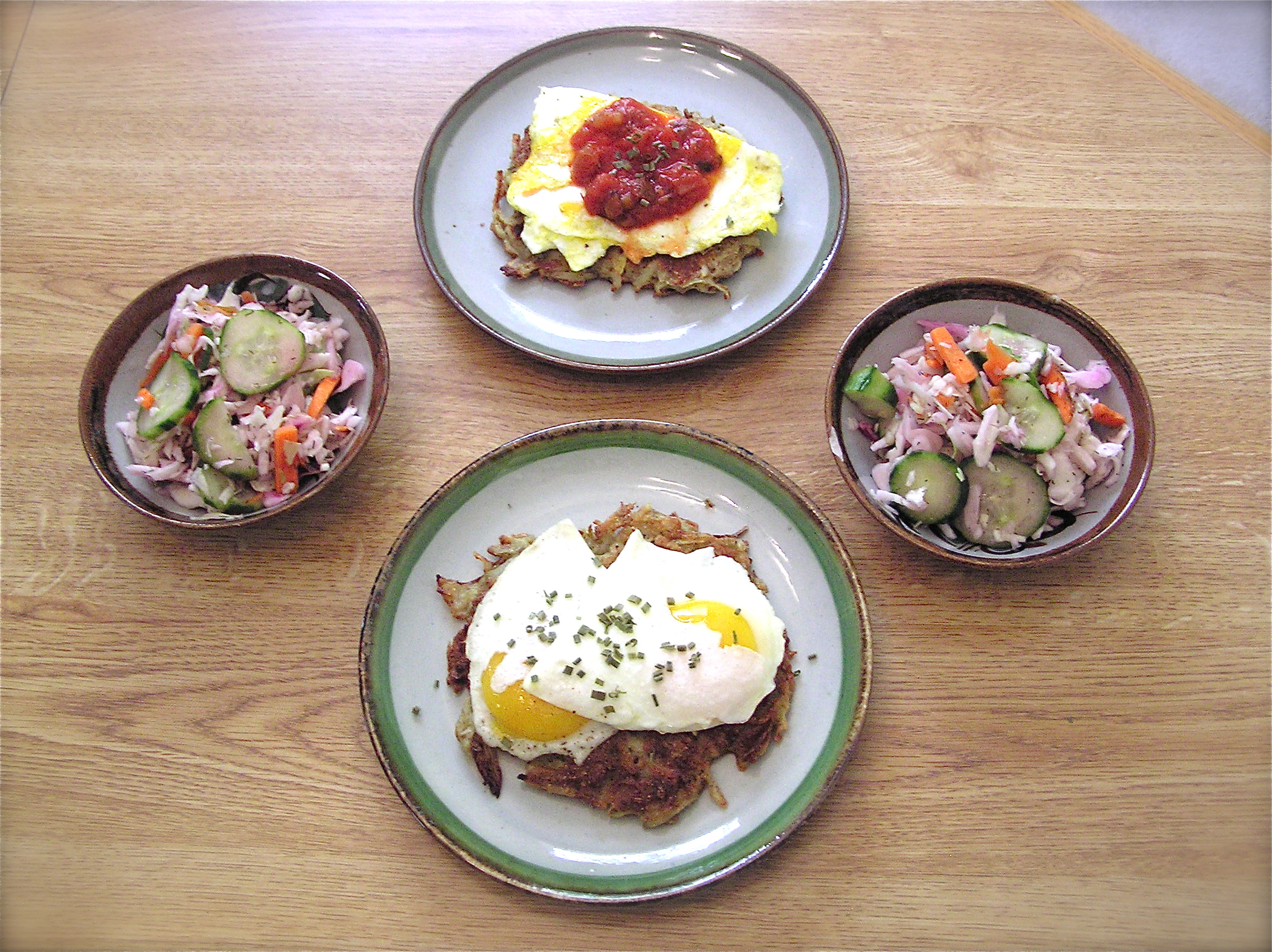Big Breakfast Latkes with scrambled eggs and salsa (top) and eggs over easy (bottom), with two sides of cucumber slaw.