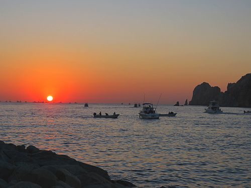 A group of fishing boats out to sea at dawn.