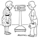 A woman stands in front of weight scale while talking to her nurse.