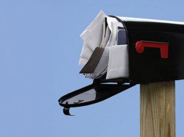 An open mailbox stuffed full of letters. Source: Shutterstock.com