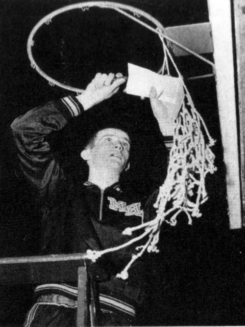 Bob Plump celebrates the basketball shot heard from Milan, Indiana, to Hollywood by cutting down the net. (Photo courtesy of W. M. Krider/Lawenceburg, Jr.)