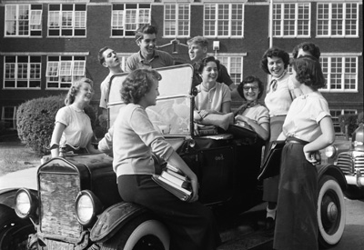 High school kids "hanging out" around a jalopy.