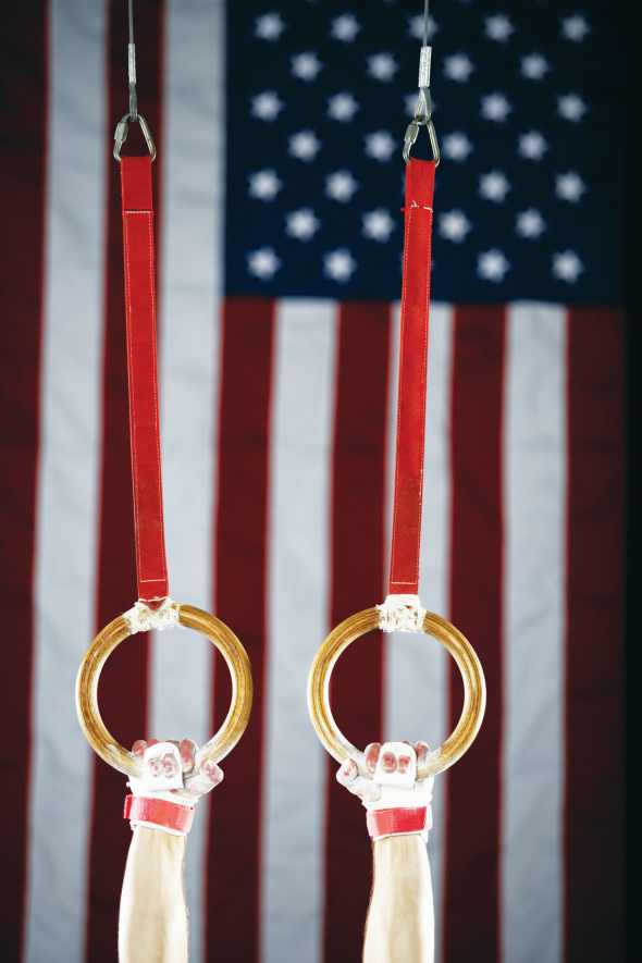 A gymnast's hands grasping rings.