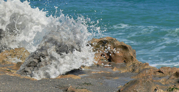Ocean breaking on rocky shore at Blowing Rocks Preserve in Florida