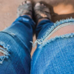 A pair of jeans that are torn at the knees.