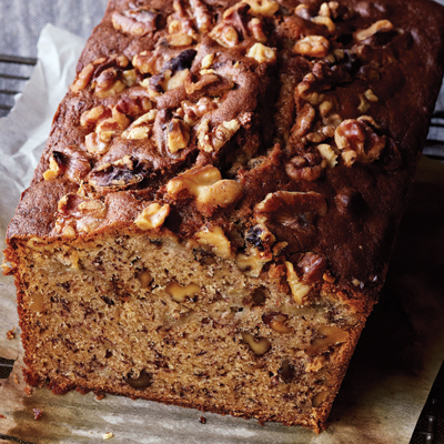 A loaf of banana bread, topped with walnuts