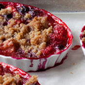 berry crumble desserts in creme brulee dishes on oven sheet