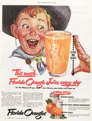 Boy smiling at glass of orange juice
