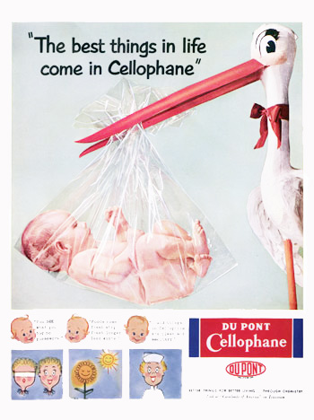 Paper mache stork holding baby wrapped in cellophane