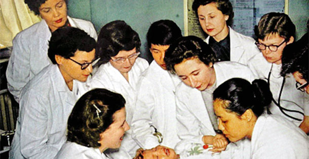 Student doctors hovering over child