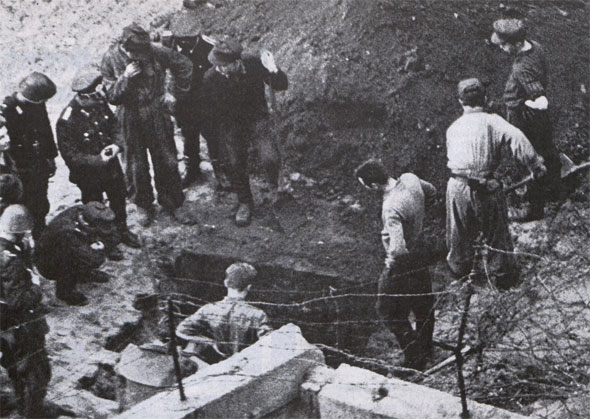Too late, East German police tear up street after finding yet another tunnel near the wall.