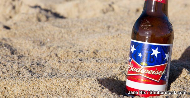 A bottle of Budweiser in the sand
