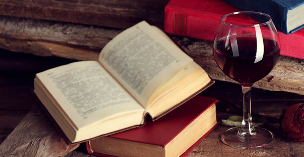 A glass of wine next to a book