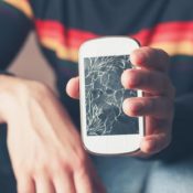 Man holding a cracked mobile phone