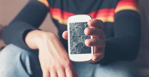 Man holding a cracked mobile phone