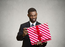 Man looking perplexed at a giftbox he didn't want.