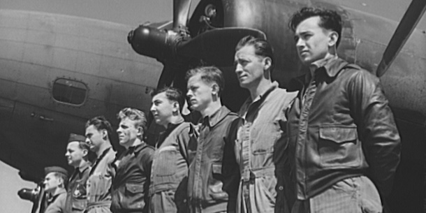 Members of the Army Air Corps stand at attention in front of one of their planes