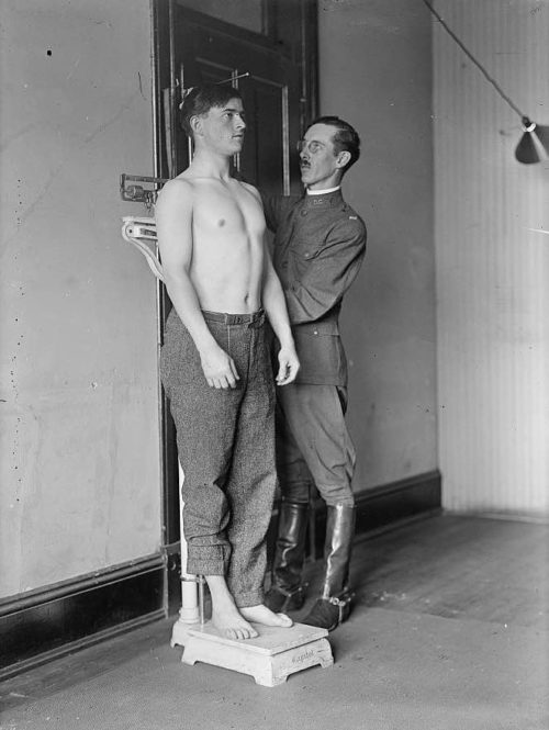 An army recruit being examined by an officer