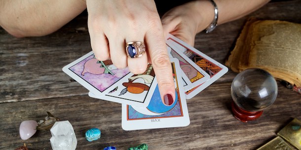 A fortune teller with a stack of tarot cards