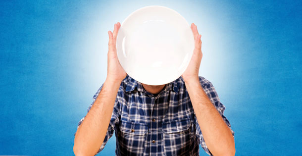 Man holding plate in front of his face