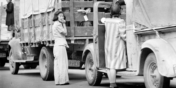 Japanese-American residents loading household belongings onto trucks.