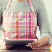 Woman cooking in kitchen; using a tablet PC