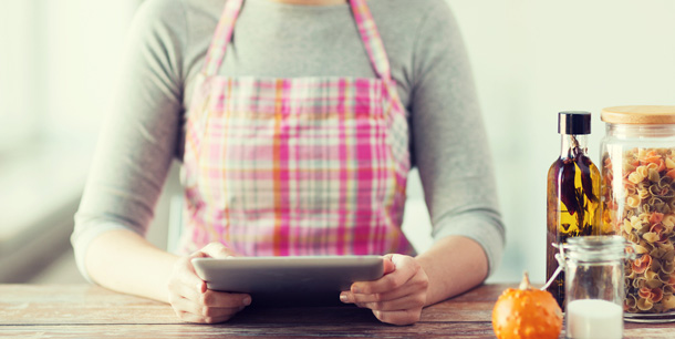 Woman cooking in kitchen; using a tablet PC