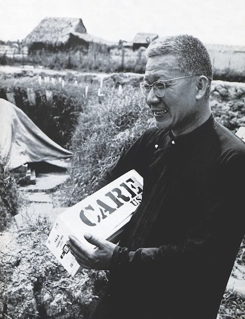 Father Hoa holding an United States care package