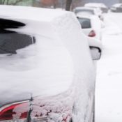 Snow covered car in a city street