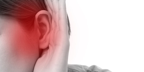 Woman holding her hand to her ear, signifying hearing loss.