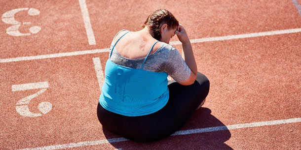 Tired runner sitting on a race track