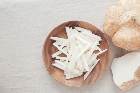 Sliced jicama in a small wooden dish.