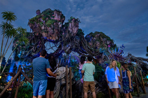 Vacationing family in front of a Disney World attraction.