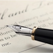 A fountain pen rests above a signature line of a will.