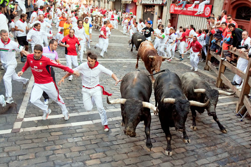 People fleeing a stampede of bulls.