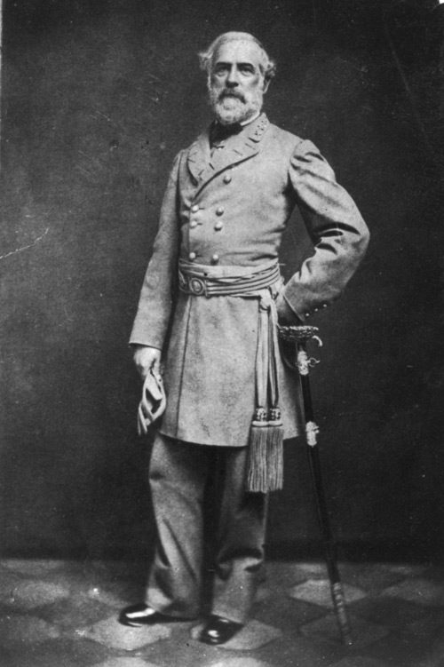 Robert E. Lee poses for a photograph in his military uniform. He leans on his sword,